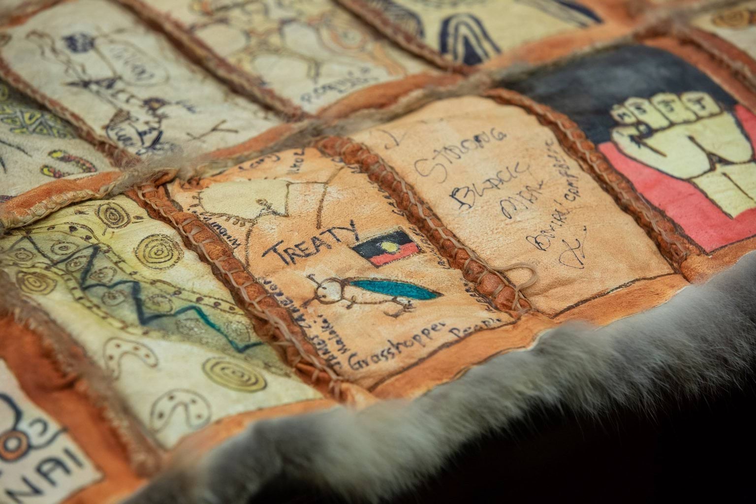 Possum skin cloak with artwork on panels about Treaty.