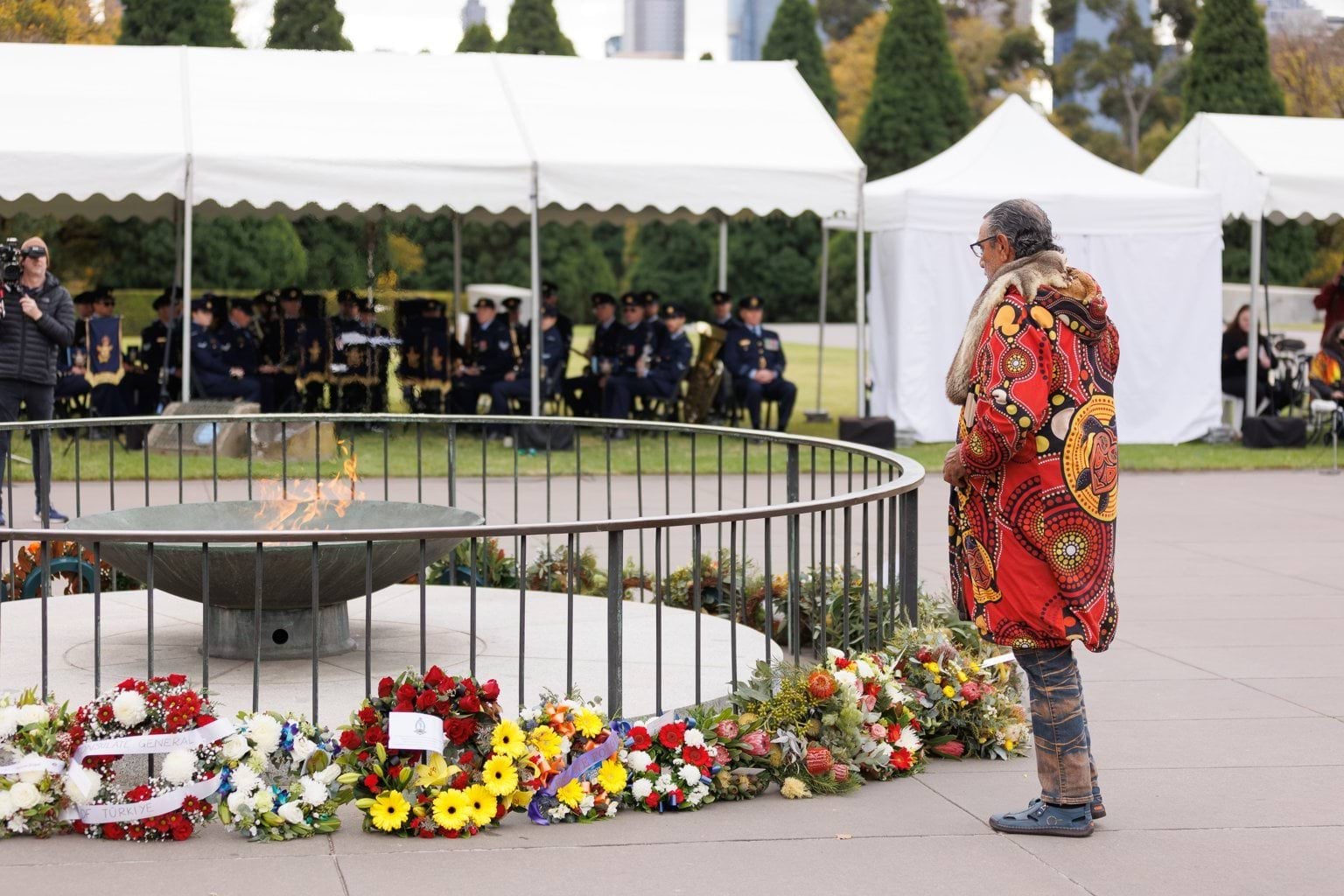 Bunurong Elder Uncle Mick Edwards stand beside the Shrine of Remembrance cauldron 