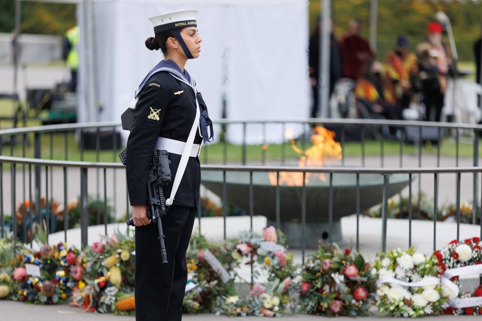 A member of the Royal Australian Navy stands besides the Shrine of Remembrance cauldron