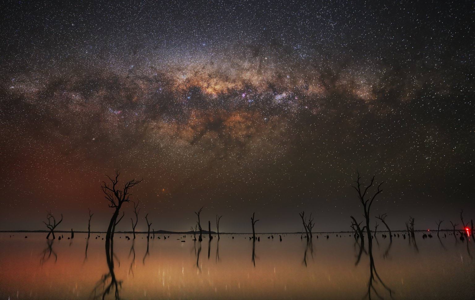 The moonlit night sky, adorned by countless stars, sets over the Kow Swamp in north-central Victoria 